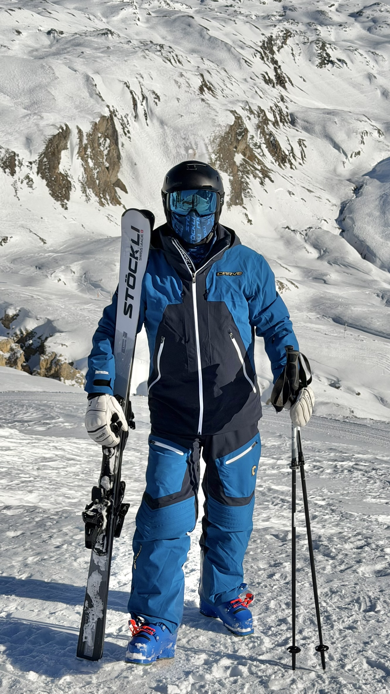 Adam holding Stöckli skis in the Alps